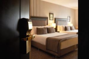 イスタンブールにあるアバンギャルド ホテル タクシムのベッド2台とテレビが備わるホテルルームです。