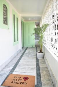 a rug on a hallway with a green door at Axom Aura in Tezpur