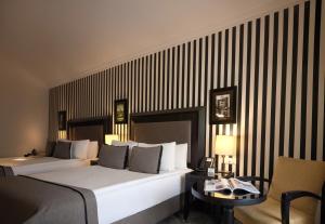 イスタンブールにあるアバンギャルド ホテル タクシムのベッド、テーブル、椅子が備わるホテルルームです。