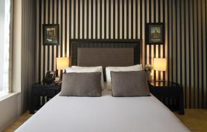 1 dormitorio con 1 cama blanca grande y 2 almohadas en Avantgarde Hotel Taksim, en Estambul
