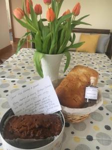 een tafel met een vaas met bloemen en een brood bij Bwthyn Derrick in Tal-gareg