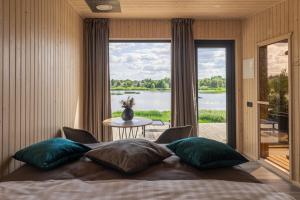 a bedroom with a bed with a view of a lake at Doles Perle in Ķekava