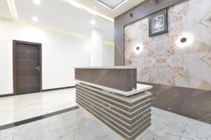 un vestíbulo con una pared de piedra y un mostrador en Hotel ANGAN, en Udaipur