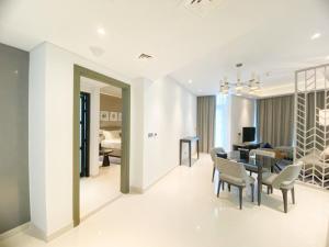 a dining room and living room with a table and chairs at Comfy 1BR in Damac Maison Prive by Huaxia Homes in Dubai