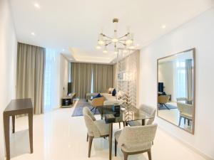 a dining room and living room with a table and chairs at Comfy 1BR in Damac Maison Prive by Huaxia Homes in Dubai