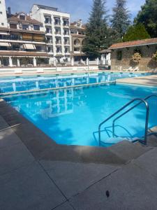 a large swimming pool with blue water in a building at El pequeño capricho in Arenas de San Pedro