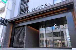 札幌的住宿－KOKO HOTEL Sapporo Odori，城市街道上建筑物前面的商店