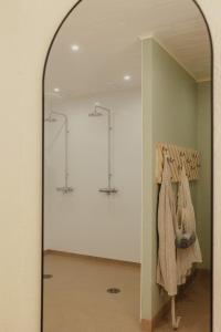 a mirror in a room with clothes on a rack at Pistocamp in Puumala