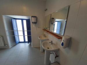 uma casa de banho com 2 lavatórios e um espelho em Albergue Villares de Orbigo em Villares de Órbigo