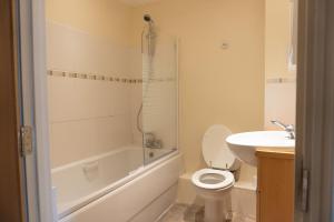 a white bathroom with a toilet and a sink at The Cozy Covert in Spondon, Derby in Derby
