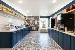 a kitchen with blue cabinets and a tile floor at Redwood Lodge in Redwood Falls