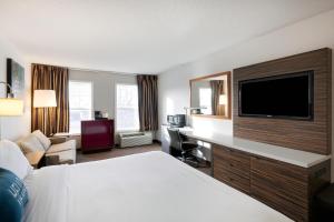 um quarto de hotel com uma cama e uma televisão de ecrã plano em Redwood Lodge em Redwood Falls
