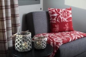 ein Sofa mit einem roten Kissen und zwei Gläser auf dem Tisch in der Unterkunft Spidsbergseter Resort Rondane in Venabygd