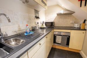 a small kitchen with a sink and a stove at Cottage in the Heart of Brixham in Brixham +18 photos