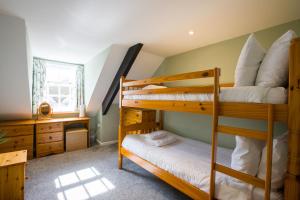 a bedroom with two bunk beds and a desk at Cottage in the Heart of Brixham in Brixham