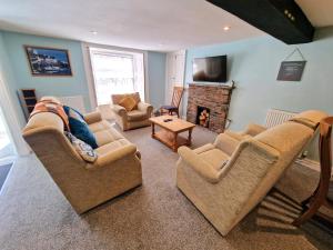 a living room with two couches and a fireplace at Cottage in the Heart of Brixham in Brixham
