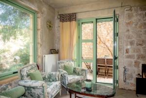 a living room with chairs and a table and a window at Eternia Suites in Katakoúli