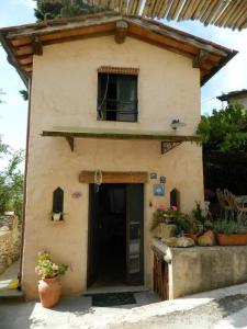 een klein huis met een deur en een raam bij Gemütliches Landhaus in ruhiger Lage mit herrlicher Pergola und Blick bis zur Küste in Montigiano