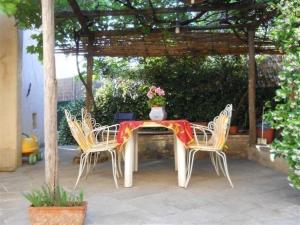 een tafel met twee stoelen en een vaas met bloemen erop bij Gemütliches Landhaus in ruhiger Lage mit herrlicher Pergola und Blick bis zur Küste in Montigiano