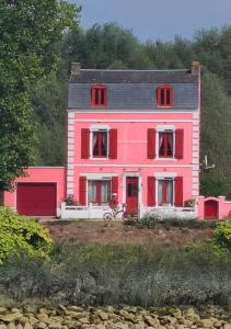 różowy dom z rowerem zaparkowanym przed nim w obiekcie au 10 quai violette w mieście Saint-Valéry-sur-Somme