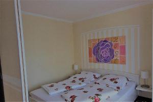 1 dormitorio con 1 cama con una pintura en la pared en Ferienwohnung Romantic, en Bad Kissingen