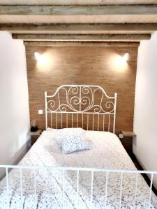 uma cama branca num quarto com uma parede de tijolos em 2 bedrooms house with enclosed garden and wifi at Beira em Beirã