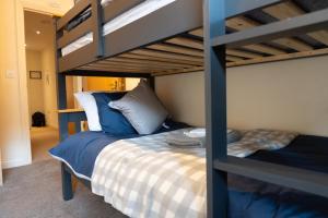 a bedroom with a bunk bed with a blue bunk bedutenewayewayangering at The Cozy Covert in Spondon, Derby in Derby