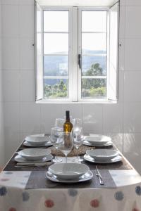 una mesa con platos y gafas y una ventana en Casa A Gateira, en O Casal Pontevedra