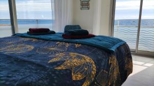 孔卡爾諾的住宿－Appartement T3 de 74m2 très lumineux vue panoramique mer et plages，一间卧室配有一张带蓝色和金色被子的床