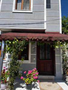una casa con flores delante de una puerta en Deniz Manzaralı Müstakil ev Aybalik, en Ayvalık