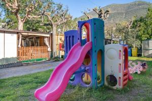 a playground with a slide in the grass at Monolocale La Pineta 46 in Albenga