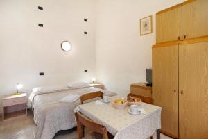 a bedroom with a bed and a table with a table and chairs at Monolocale La Pineta 46 in Albenga +22 photos