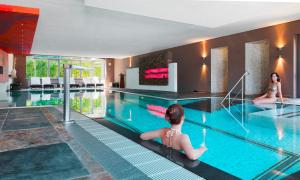 a swimming pool with two girls in a hotel at Luisenhof by Bütgenbacher-Hof in Butgenbach