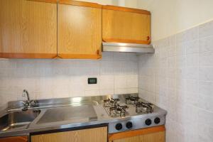 a kitchen with a sink and a stove and cabinets at Monolocale La Pineta 46 in Albenga