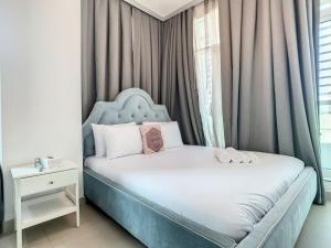 Schlafzimmer mit einem Bett mit blauem Kopfteil in der Unterkunft Key View - Hilliana Tower in Dubai