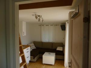 sala de estar con sofá y mesa en Kleines Ferienhaus - Tiny house - auf Gotland 700 Meter zum Meer en Ljugarn