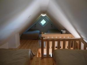 um quarto no sótão com 2 camas e uma janela em Kleines Ferienhaus - Tiny house - auf Gotland 700 Meter zum Meer em Ljugarn