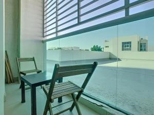 杜拜的住宿－Key View - Hilliana Tower，阳台的长椅、桌子和椅子