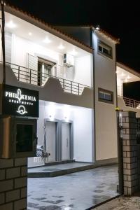 a white building with a sign on the side of it at Philoxenia Apartments Saranda in Sarandë