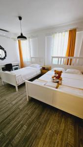 a bedroom with two beds with a teddy bear sitting on top at Ada Kalimera Bozcaada in Bozcaada