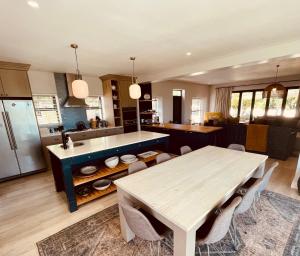 a kitchen with a wooden table and a table and a counter at Rondebos Retreat - Clifftop Peace, Tranquil Bush in Plettenberg Bay