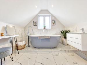 a bathroom with a large tub in a attic at Roseland Penthouse - Arundel in Arundel +16 photos