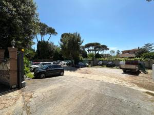 a parking lot with cars parked in a driveway at Le Querce Appartamento Roma in Infernetto