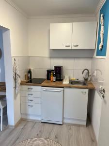 a kitchen with white cabinets and a sink at Maja Appartement in Bad Schwartau