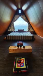 - une vue sur un lit et une table dans une tente dans l'établissement Lau Camping Phình Hồ, à Yên Bái