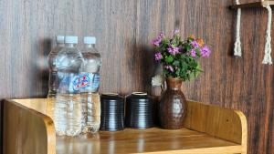 uma mesa com duas garrafas de água e um vaso com flores em Lau Camping Phình Hồ em Yên Bái