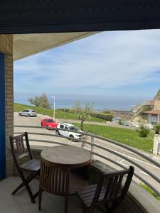 a balcony with a table and chairs and a view of the ocean at Habitaciones Hondar-Gain 10 in Zumaia