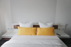 a white bed with two yellow pillows on it at Wohlfühloase im Traum-Apart in Essen