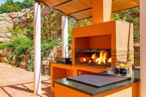 una cocina al aire libre con chimenea en un patio en Villa Filipinas, en Palafrugell