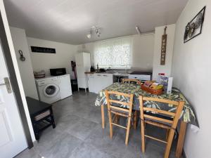a kitchen with a table and chairs and a kitchen with a washing machine at Le Domaine du Fayé in Étueffont +20 photos